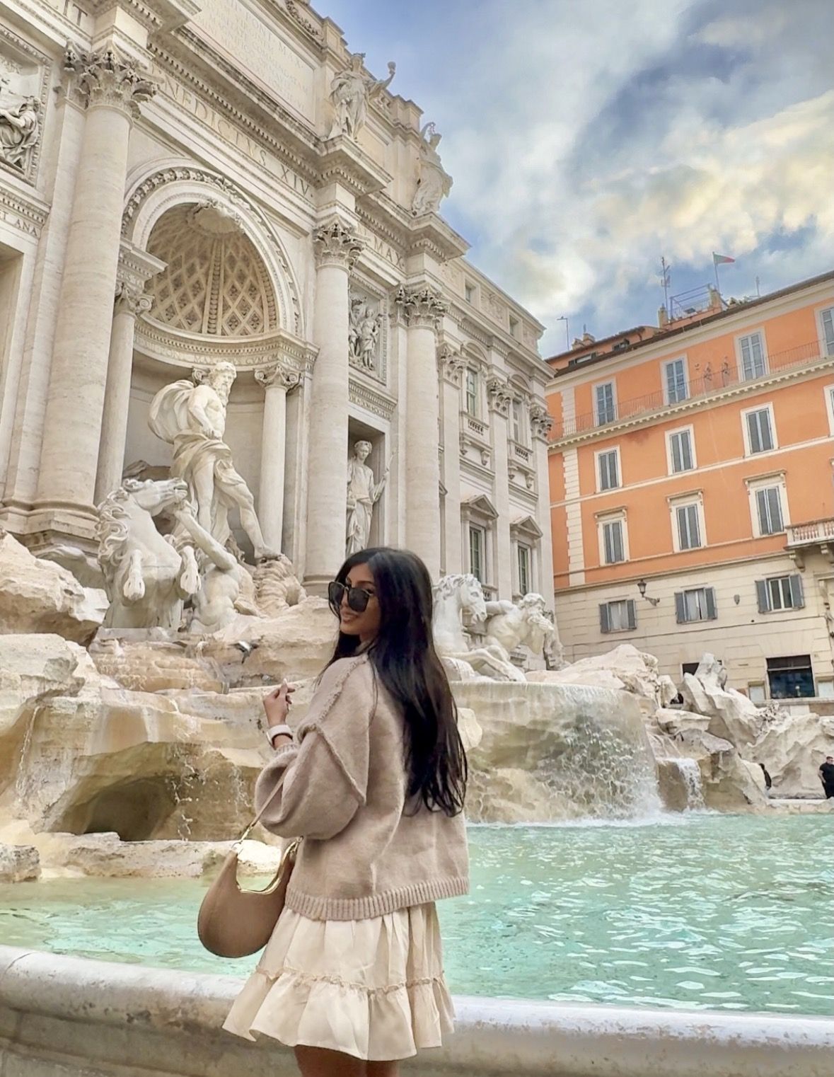Quiet early morning view of the Trevi Fountain piazza with a handful of visitors enjoying the space peacefully